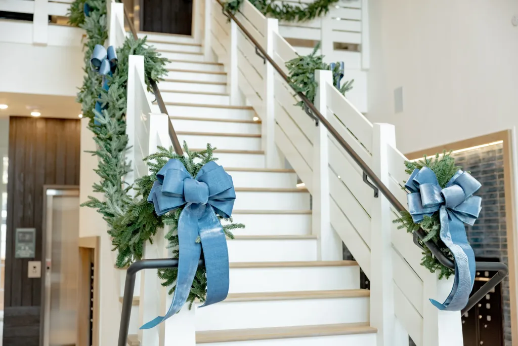 A staircase decorated with wreaths and ribbons