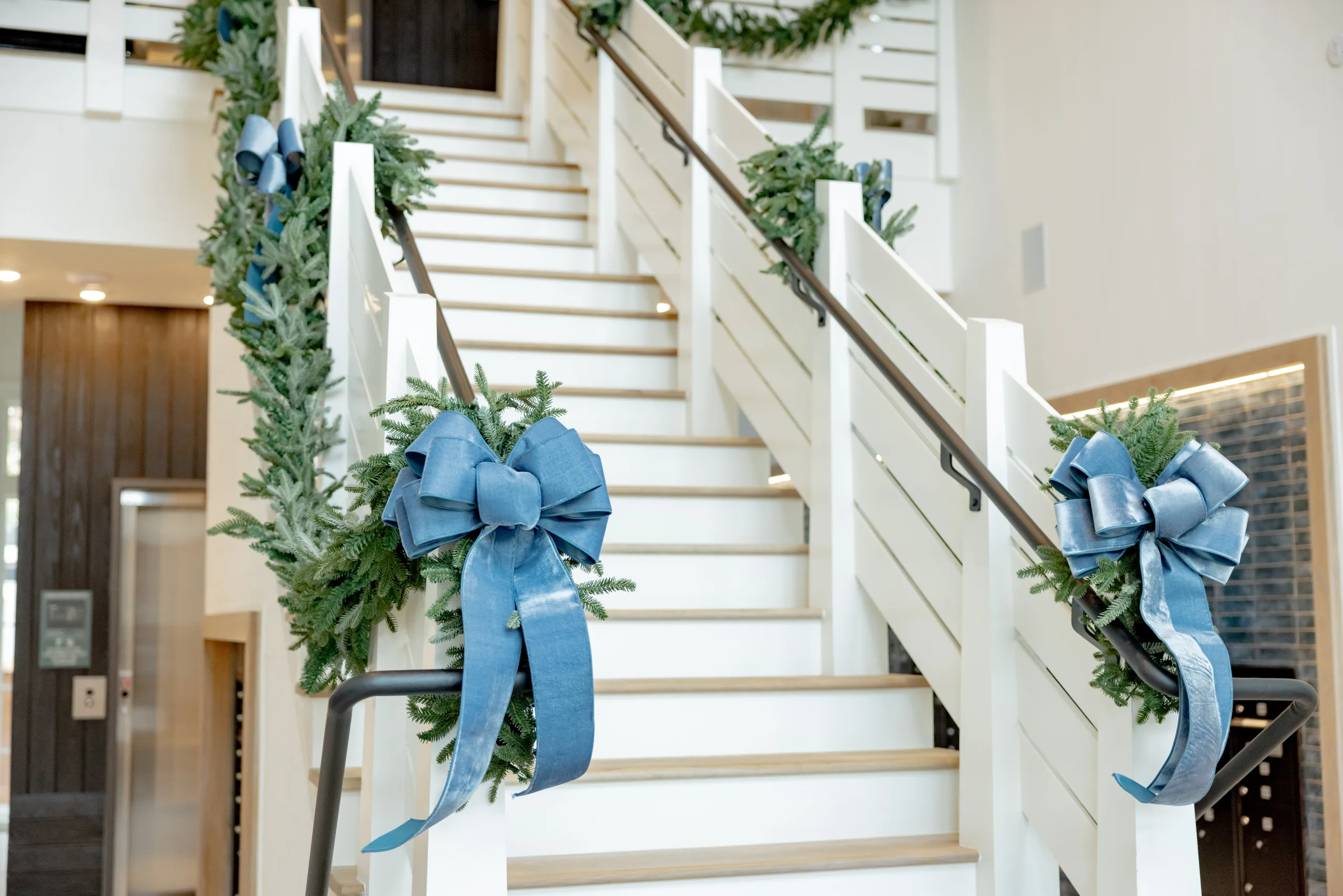 A staircase decorated with wreaths and ribbons