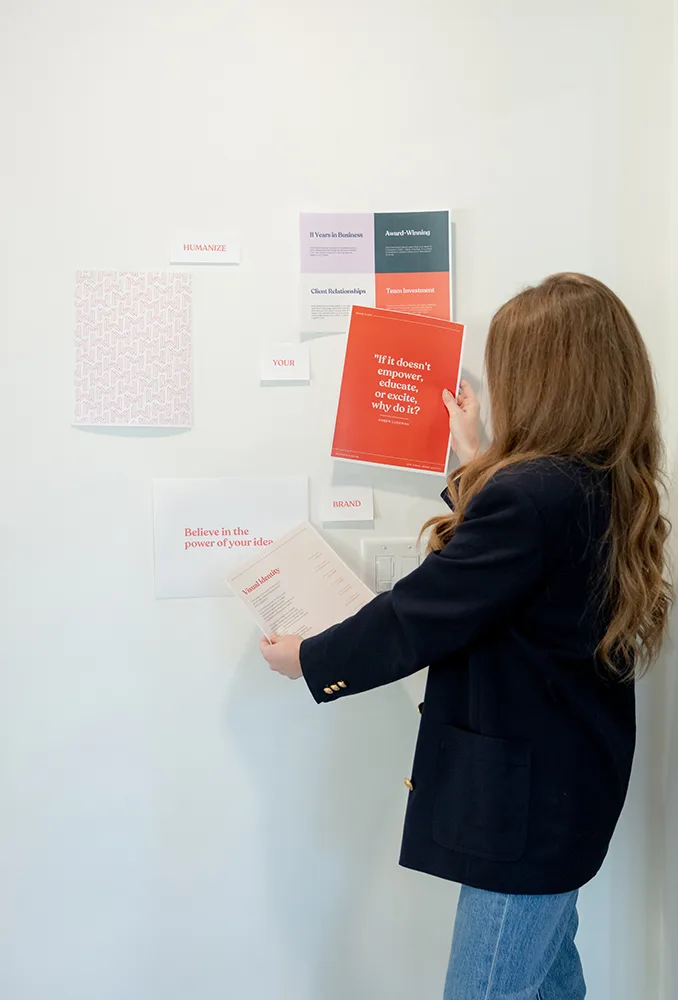 Olivia Rice of Matchstick Social mapping laying out branding elements on a wall