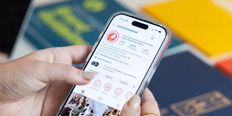 Marketer reviewing Instagram analytics on a smartphone while tracking marketing metrics that matter and key B2B marketing metrics.