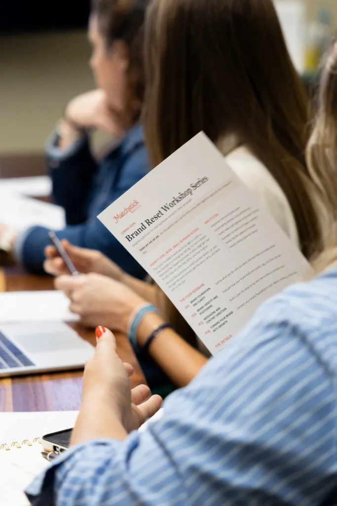 members of Matchstick's brand reset workshop sit at a table and hold a worksheet