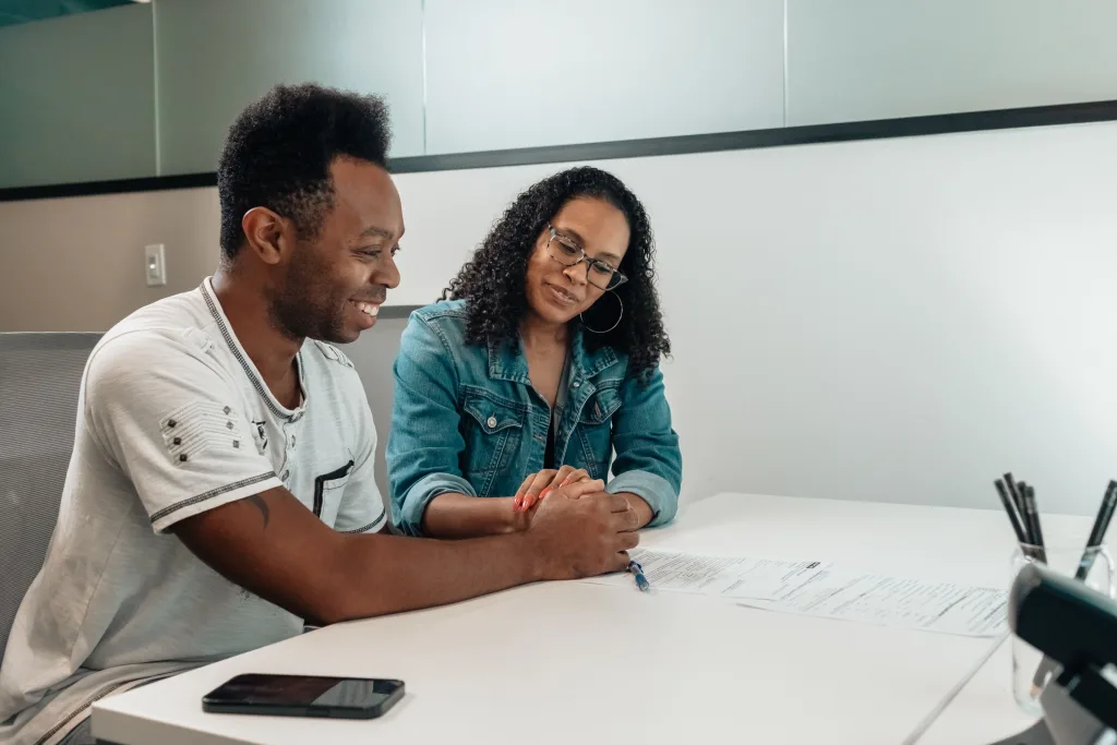 Small business owner showing a customer how to leave a Google review on a phone.